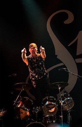 Steve Pinnell standing on the drum kit